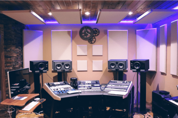 A Music Studio With Purple Lighting Above and White Panels on the Wall
