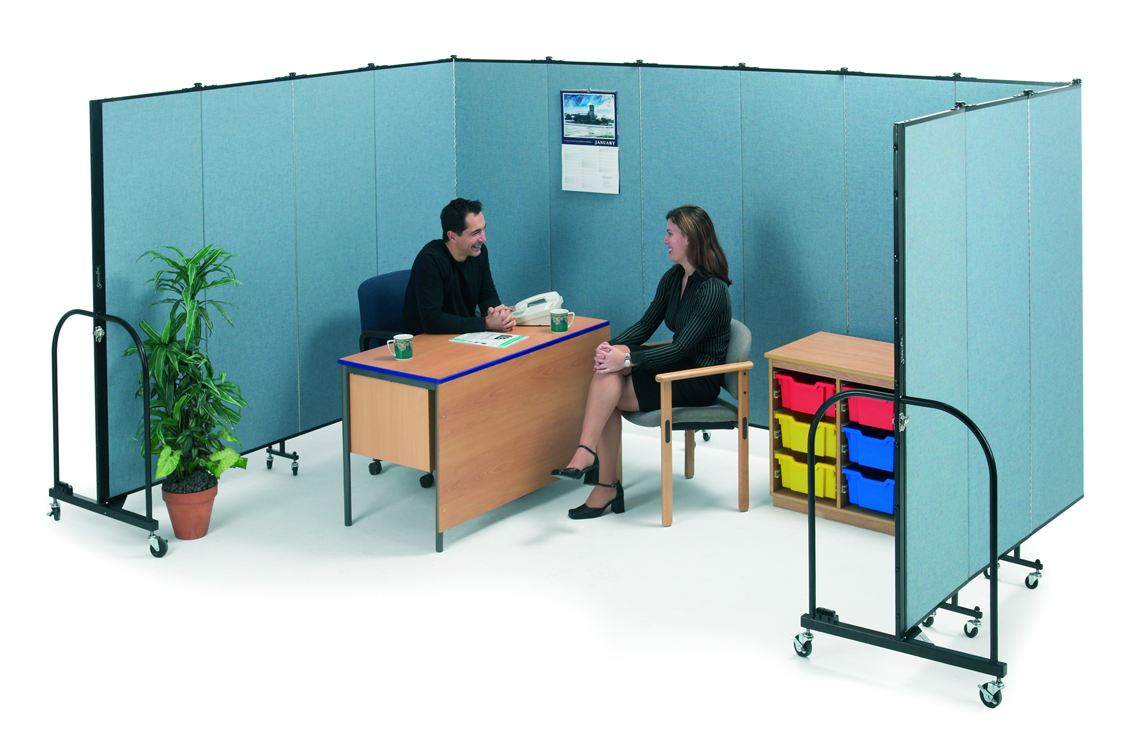 Colleagues sitting at a desk talking behind a screenflex Portable Partition